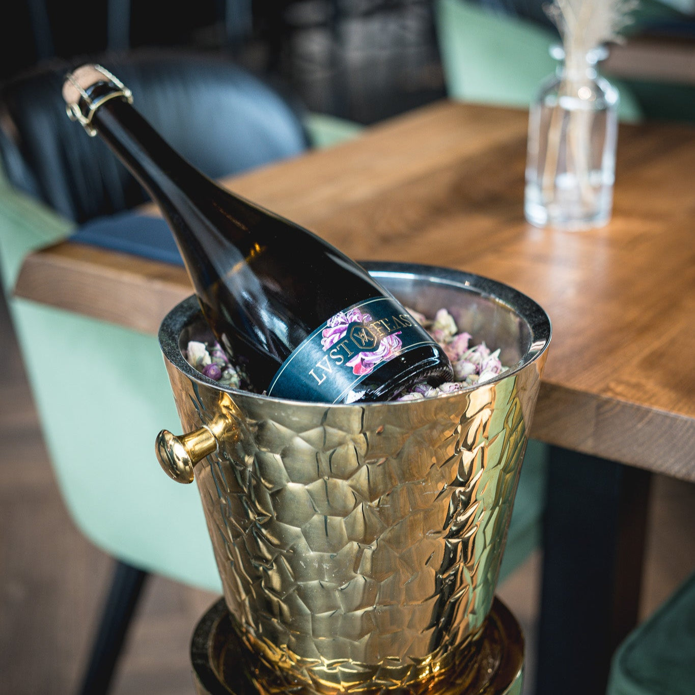 Bottle of Lust & Feast Rose in bottle cooler with rose blossoms
