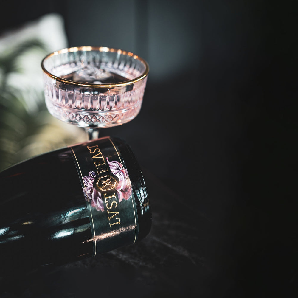 
                  
                    Flasche von LUST & FEAST ROSE neben edlem Glass als alkoholfreie Alternative Schaumwein
                  
                
